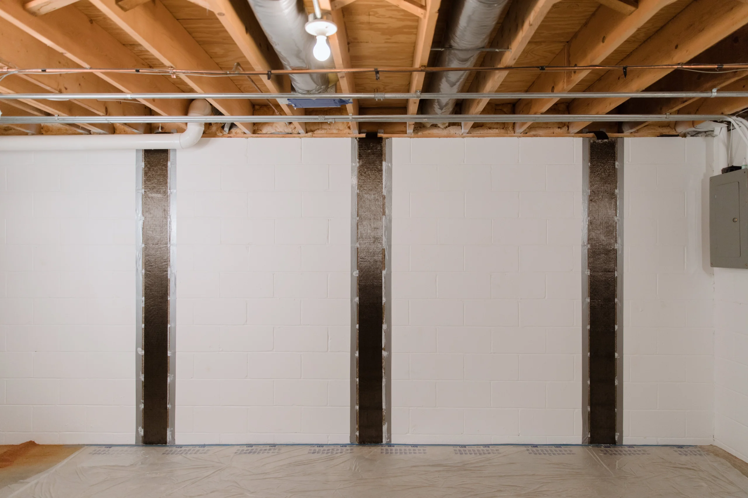 Carbon Armor A finished basement wall stabilized with carbon fiber straps for foundation repair.